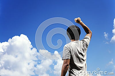 Man clench fist facing the sky Stock Photo