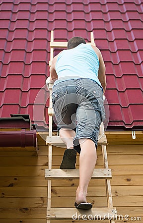 The man climbed the stairs to check the roof of the house after the hurricane Stock Photo