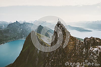 Man climber standing on cliff mountain edge above fjord in Norway Stock Photo