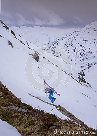 Man climbing mountain on ski tour with skis on back, Zillertal Austria Editorial Stock Photo