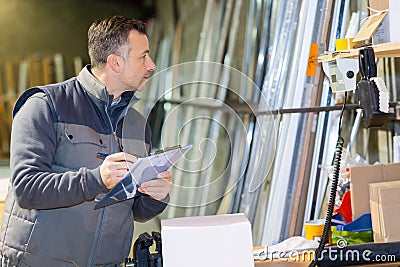 man with clipboard in factory preparaing parcel for despatch Stock Photo