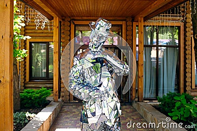 A man in clothes from mirrors poses on a background of wood, brilliant style, disco, beautiful show, mirror man Editorial Stock Photo