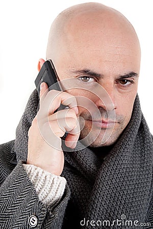 Man with coat and scarf on the phone. Stock Photo