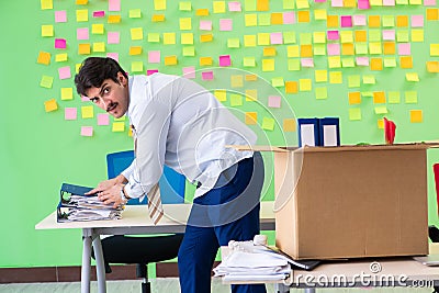 Man collecting his stuff after redundancy in the office with man Stock Photo