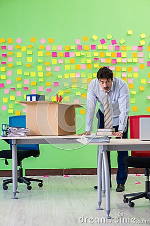 Man collecting his stuff after redundancy in the office with man Stock Photo