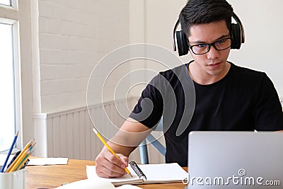 Man college student studying learning lesson with computer online taking note Stock Photo