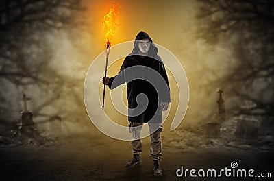 Man coming out from a thicket with burning flambeau Stock Photo