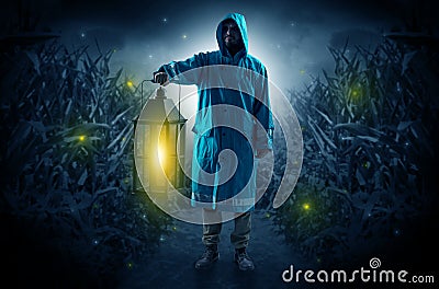 Man coming out from a thicket with lantern Stock Photo