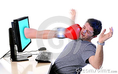 Man with computer hit by boxing glove Stock Photo