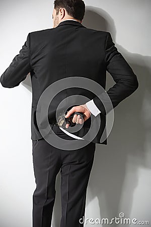 A man conceals a firearm in the back Stock Photo