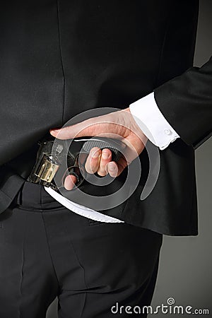 A man conceals a firearm in the back Stock Photo