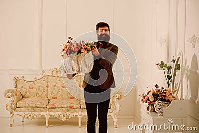 Man concept. Man with beard hold basket with roses. Man florist with flower decor. Man got flowers for holiday Stock Photo