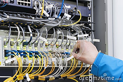 Man connecting network cables to switches Stock Photo