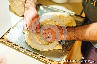 man cook Traditional Georgian dish khachapuri ajarian. National Georgian pastries with cheese and raw eggs Stock Photo