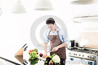 Man cooking food in minimalist kitchen Stock Photo