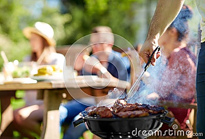 Man cooking meat on barbecue grill at summer party Stock Photo