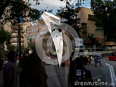 Man costume in a shop showcase reflects the people in the street. Shopping Stock Photo