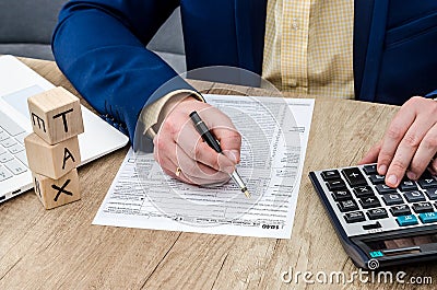 Man counting on calculator and filing 1040 form. Editorial Stock Photo
