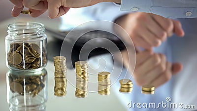 Man counting coins, increase of income, financial pyramid concept, investment Stock Photo