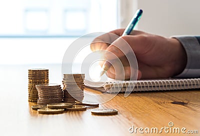 Man counting expenses, budget and savings and writing notes. Stock Photo