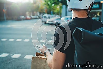 Man courier using a map app on mobile phone to find the delivery address in the city. Anonimous Courier delivery food Stock Photo