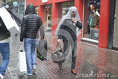 The man covered his head by jacket in heavy rain. Editorial Stock Photo