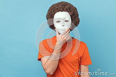 Man covering her face with white mask, hiding her real personality, anonymity. Stock Photo