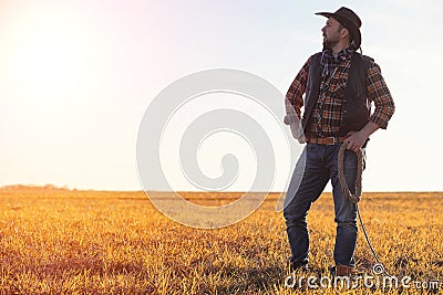 A man cowboy hat and a loso in the field. American farmer in a f Stock Photo