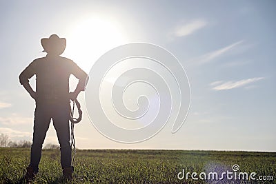 A man cowboy hat and a loso in the field. American farmer in a f Stock Photo