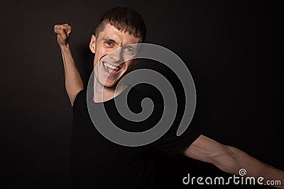 Man creaming with joy isolated on black background. Happiness, fan win concept Stock Photo