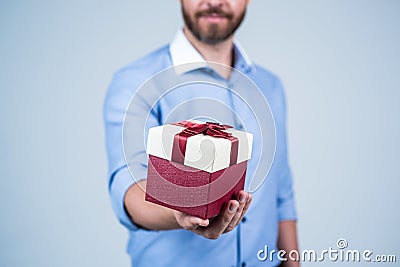 Man cropped view gift present box pack tied with red ribbon selective focus, gifting Stock Photo