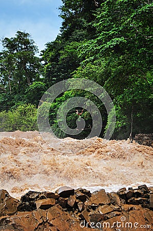 A man crosses the Mekong Khone Phapheng Falls waterfalls in Southern Laos on cables Editorial Stock Photo