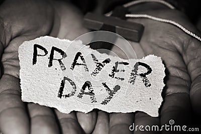 Man with crucifix and text prayer day Stock Photo