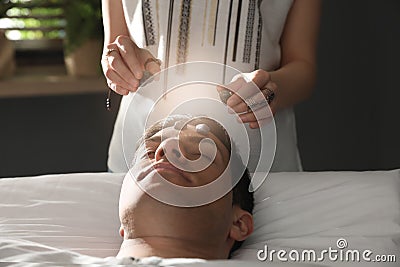 Man during crystal healing session in room Stock Photo