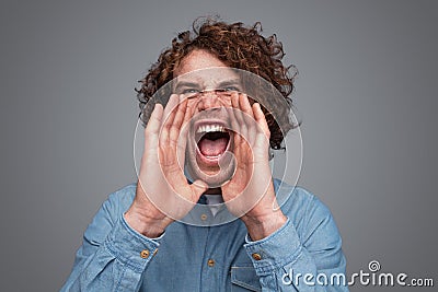 Man with curly hair screaming at distance Stock Photo