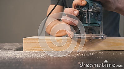 Man cut wooden chamfer by handy machine in workshop Stock Photo