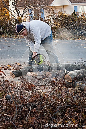 Man Cuts Tree Limbs with a Chainsaw Stock Photo