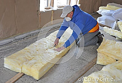 Man cutting fiberglass insulation Stock Photo