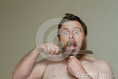 Man cutting his hair with a sharp knife Stock Photo