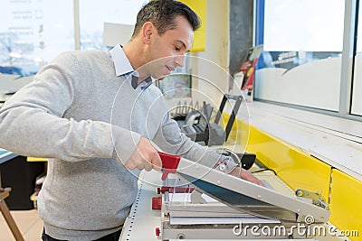 man cutting print with precision machine Stock Photo
