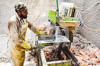 A man cutting rock salt to make tiles & bricks Editorial Stock Photo