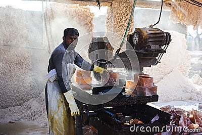 A man cutting rock salt to make tiles Editorial Stock Photo