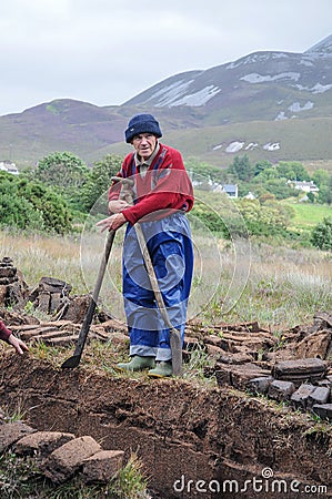 Peat cutter at work in Ireland Editorial Stock Photo