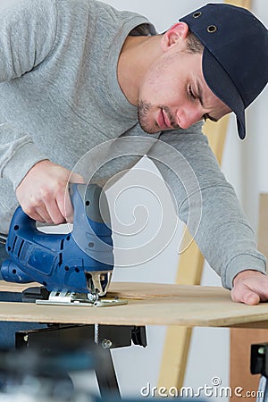 Man cutting woodplank using bandsaw Stock Photo