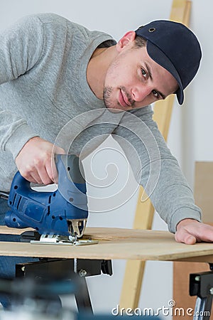 man cutting woodplank using bandsaw Stock Photo