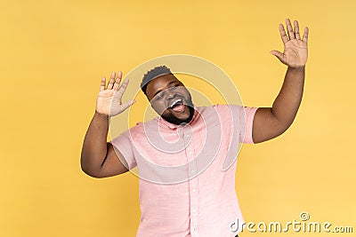 Man dancing, raising hands up and having fun, being in good mood, celebrating. Stock Photo