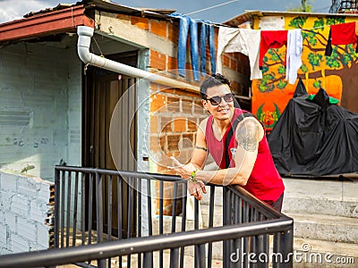 Man with Dark Glasses and Red Shirt Doing the Peace sign with his Fingers Editorial Stock Photo