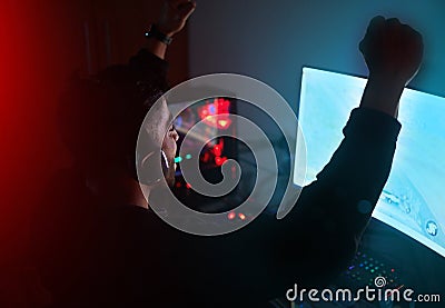 Man in dark room, video game win with fist pump and online streaming, gaming competition and esports on computer Stock Photo