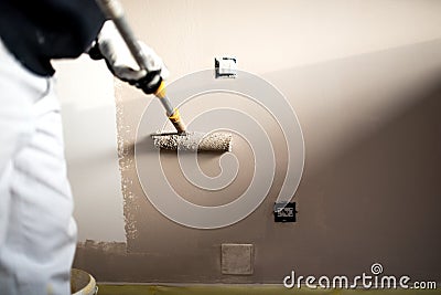 Man decorating walls with paint. Construction plaster worker painting and renovating with professional tools Stock Photo