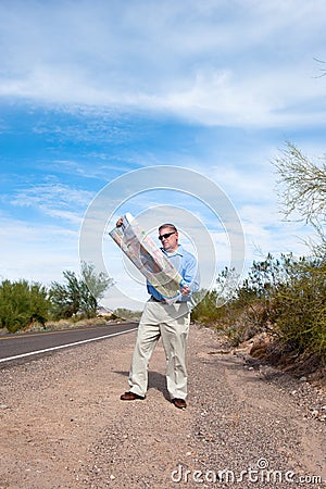 Man on deserted road reading map Stock Photo